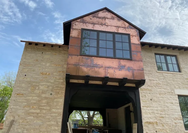 Copper metal panel facade on a stone building for Roof Repair in Alfred