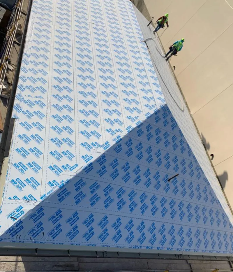 Professional roofers installing underlayment on a metal roof in Alfred